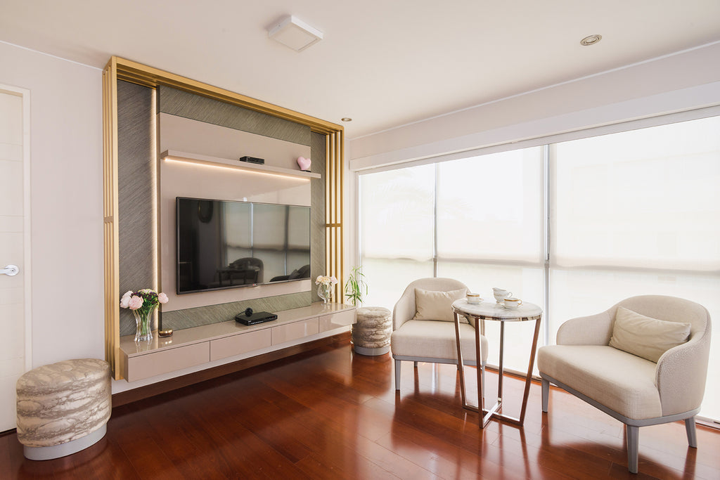 Foto de una parte de un dormitorio principal. Hay una mesa pequeña con dos sillones chicos y una televisión. 